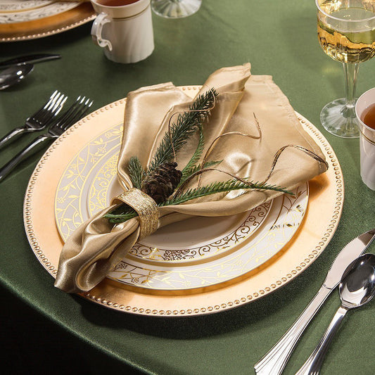 A sophisticated fall table decor with disposable plates, gold napkins, and silverware, enhancing the dining experience with elegance.