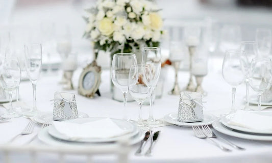 A beautifully arranged table with white tablecloths and elegant silverware, perfect for winter wedding ideas.