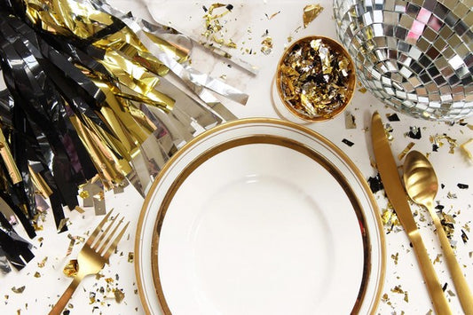 Luxurious table setting in gold and black, beautifully arranged for a celebratory New Year's Eve food.